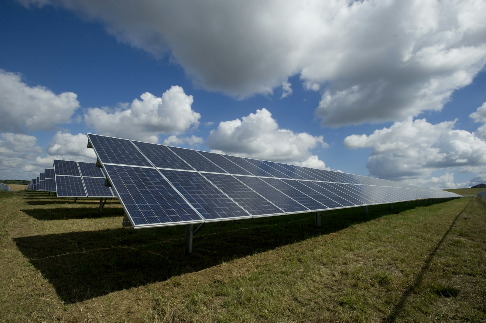Solar panels in arid landscape under bright daylight sky — desert energy editorial, no neon