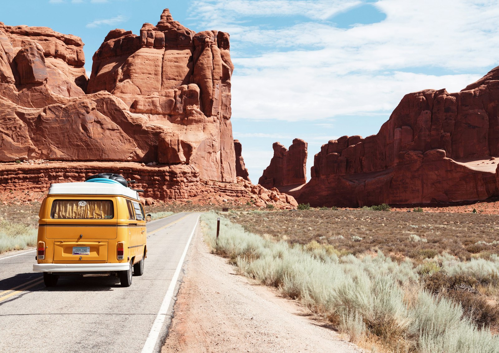 Rocky red desert plateau and arid scrub under clear daylight — landing-site landscape editorial, no neon