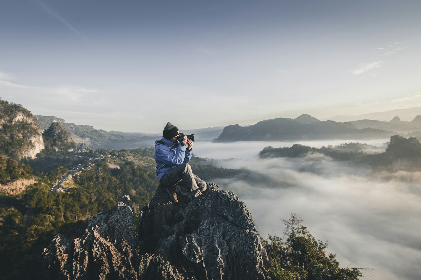 Creator filming with camera on rocky mountain overlook — video creator lifestyle